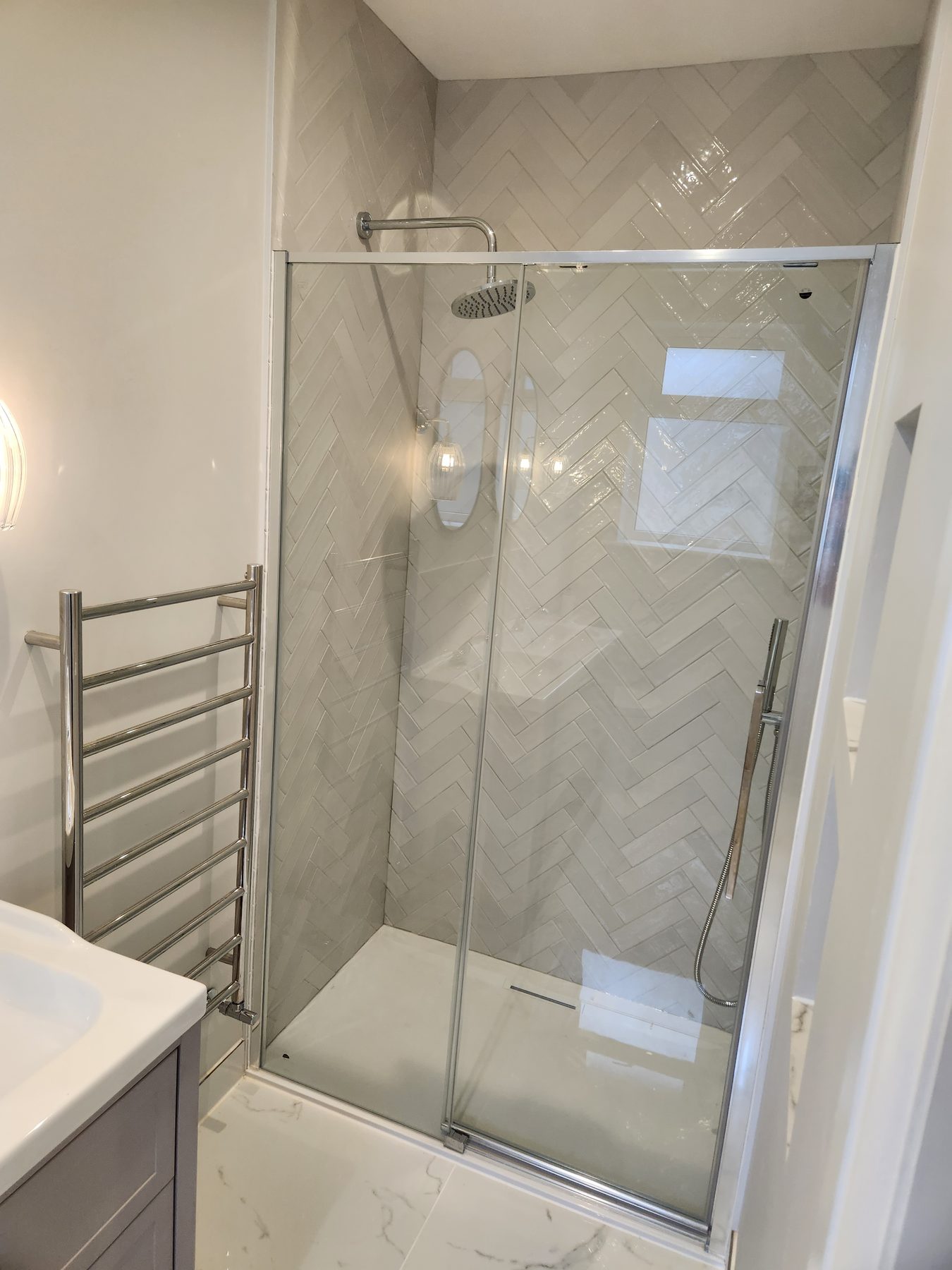 Walk-in shower with rainfall head and herringbone tiling