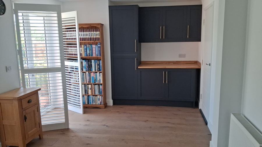 Fitted utility cupboards in navy with a timber worktop